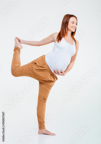 Smiling pregnant woman doing stretching exercise