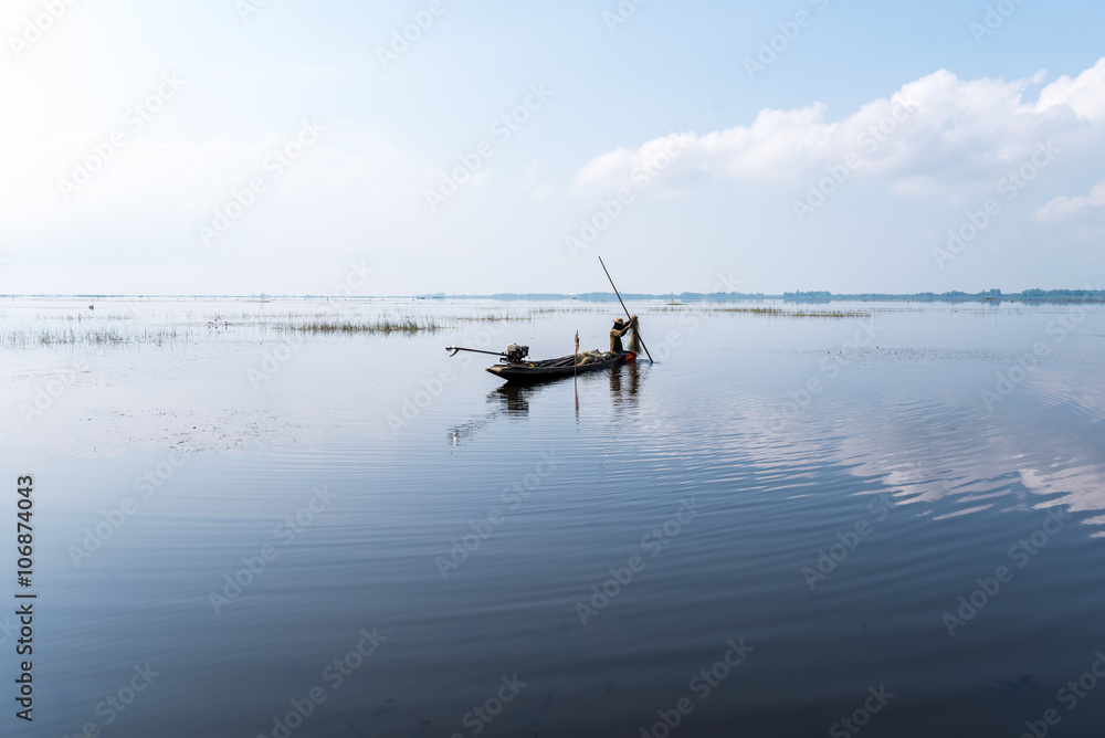 Fisherman on boat at wet land. Fisherman on boat at wet land.