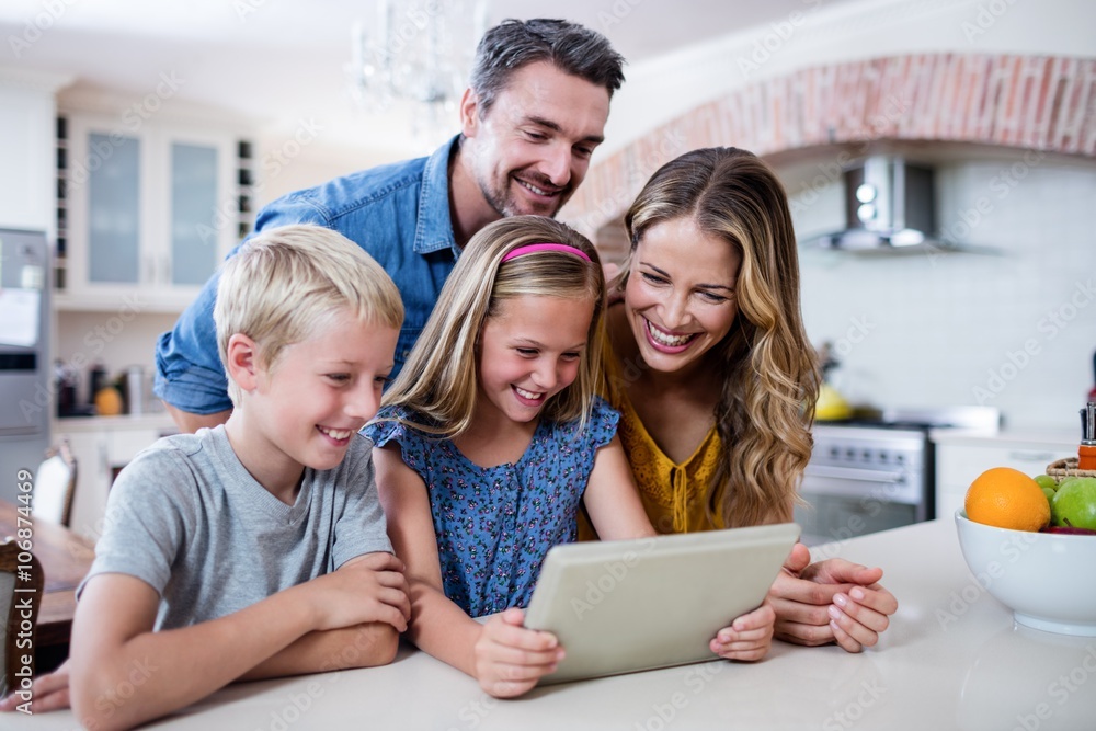Parents and kids using digital tablet in kitchen Parents and kids using digital tablet in kitchen
