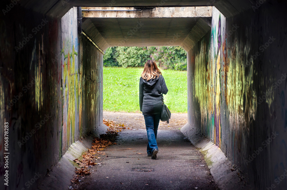woman walk alone tunnel dark underpass 