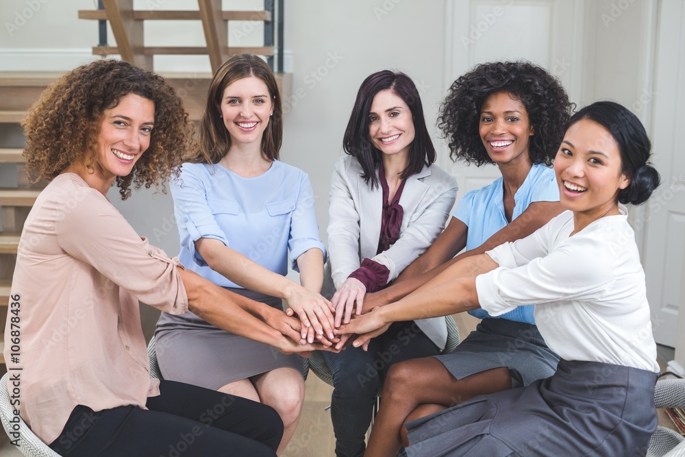 Female business colleagues putting their hands together Female business colleagues putting their hands together