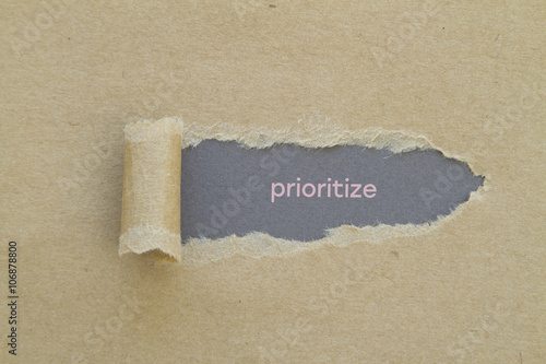 Prioritize word written under torn paper.