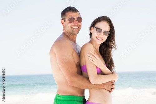 Smiling couple hugging on the beach