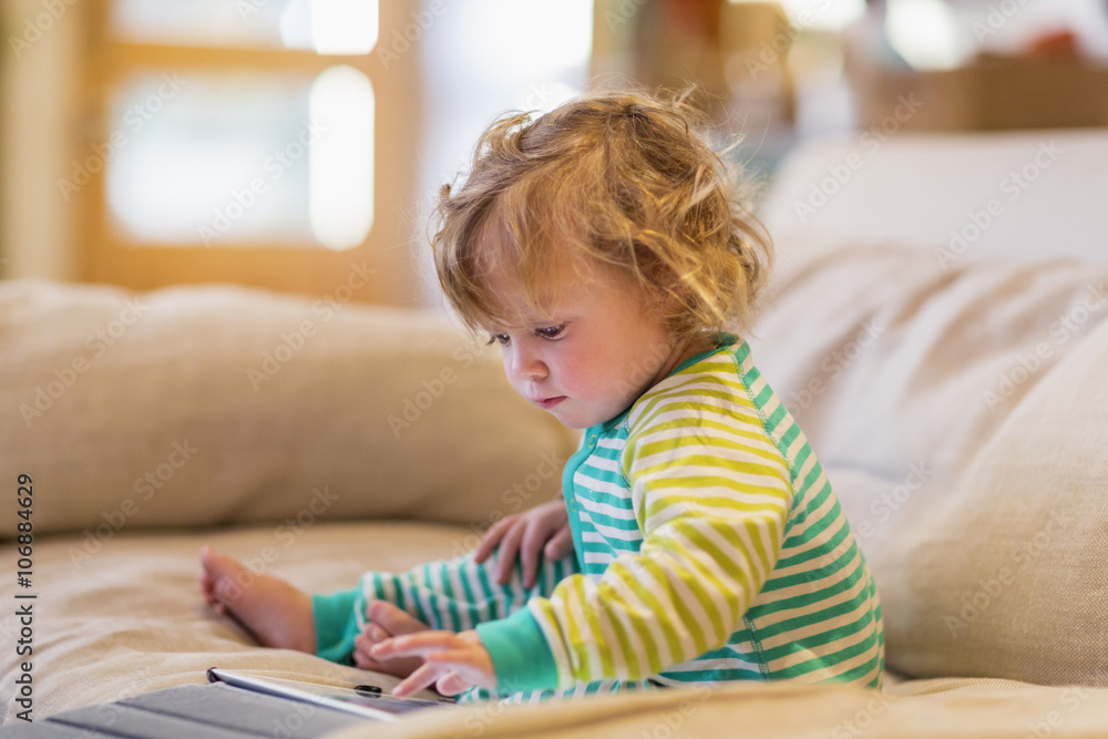 Caucasian baby boy using digital tablet on sofa Caucasian baby boy using digital tablet on sofa
