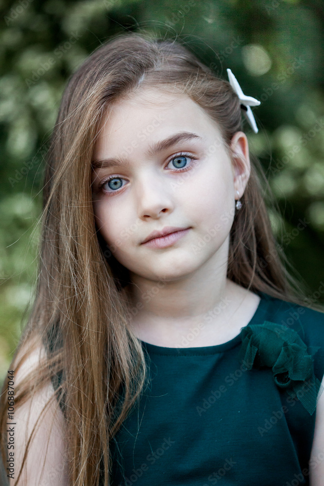 Spring fairy. Portrait of beautiful little girl with brownish blond hair and blue eyes standing outdoor on natural background. Spring fairy. Portrait of beautiful little girl with brownish blond hair and blue eyes standing outdoor on natural background.