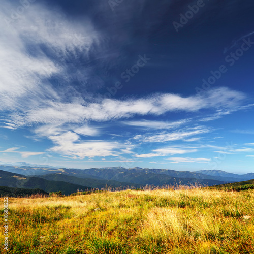 clouds over mountains and yellow grass