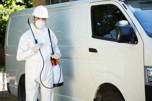 Portrait of pest control man standing next to a van photo