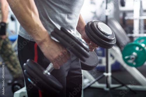 Muscular Young Man Doing Heavy Weight Exercise For Biceps With D