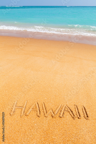 Inscription Hawaii made on beautiful beach by the blue sea
