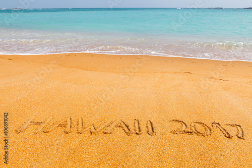 Inscription "Hawaii 2017" made on beautiful beach by the blue sea