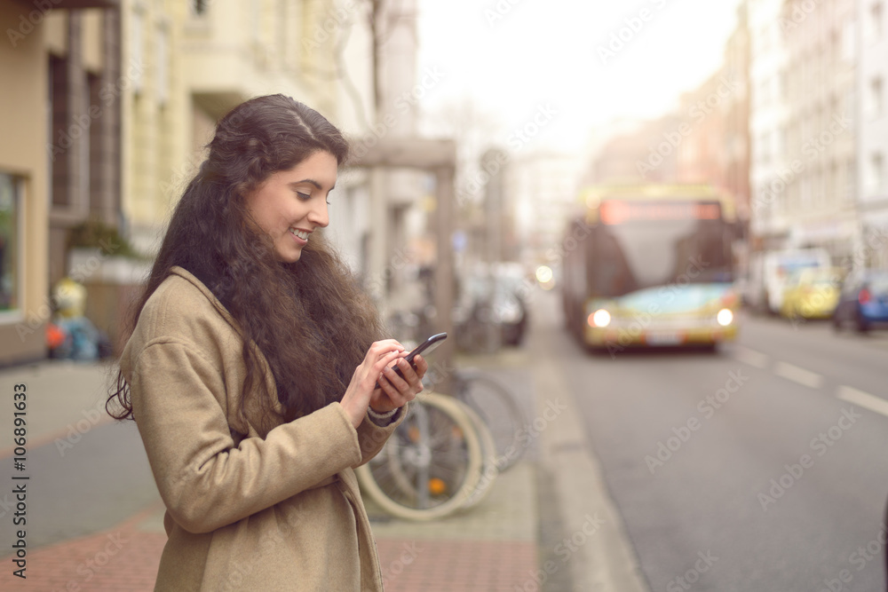 Obraz premium Brünette Frau schreibt eine Nachricht auf ihrem Handy