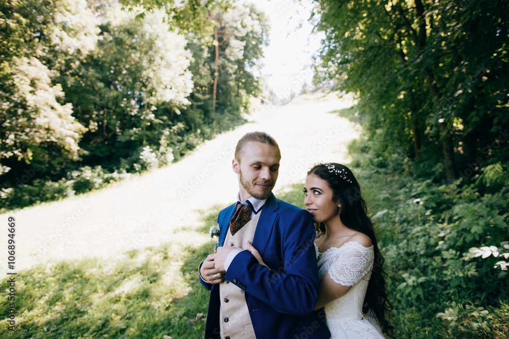 Happy sensual Bride and groom at wedding Day embracing with love. Romantic young couple celebrating their marriage in forest Happy sensual Bride and groom at wedding Day embracing with love. Romantic young couple celebrating their marriage in forest