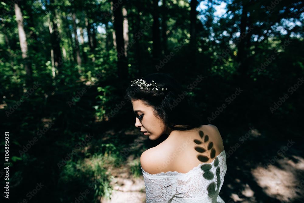 Beautiful sensual bride with rustic wedding hairstyle in the forest. Outdoor portrait of young gorgeous bride. Wedding. Shadow on the back Beautiful sensual bride with rustic wedding hairstyle in the forest. Outdoor portrait of young gorgeous bride. Wedding. Shadow on the back