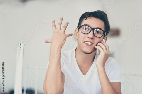 Young man in bedroom using cell phone