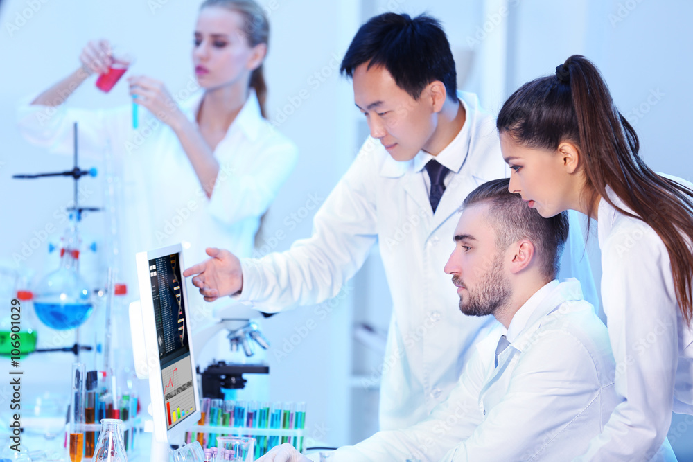 Young medical technicians working in laboratory Young medical technicians working in laboratory