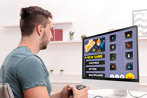 Young man playing computer ...