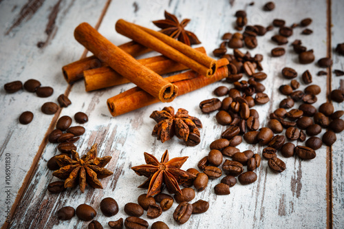 Coffee beans, cinnamon, star anise on old wooden table