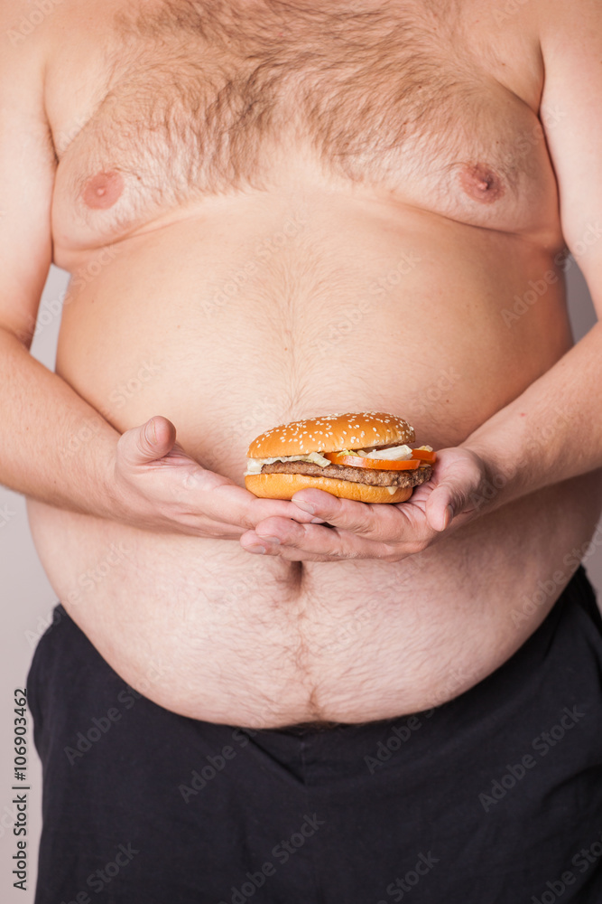a fat man with a burger in his hand a fat man with a burger in his hand