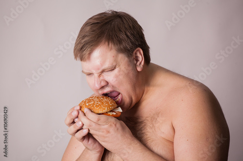 a fat man with a burger in his hand