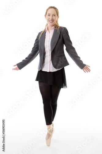 Full length studio shot of a business ballerina en pointe with her arms raised out to the sides. isolated on white