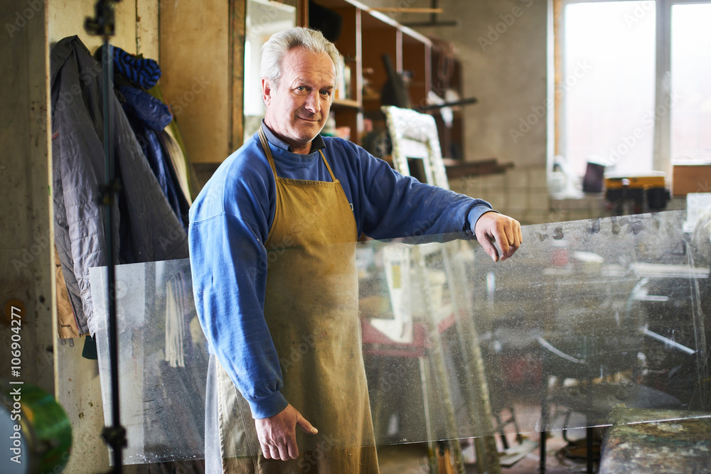 Portrait of the master which holds the glass in a workshop for the manufacture of glass