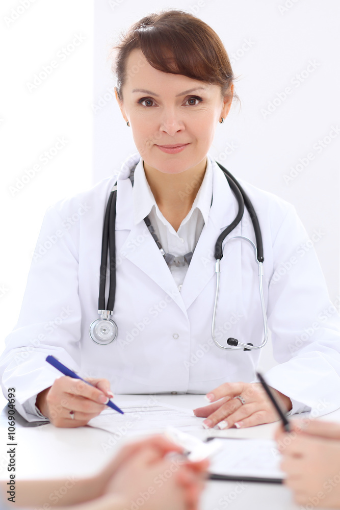 Woman doctor filling up medical history at the desk Woman doctor filling up medical history at the desk