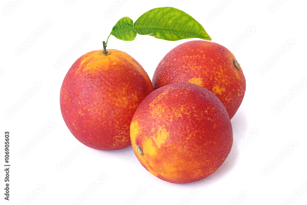 Fototapeta premium Three red oranges with leaf isolated on white