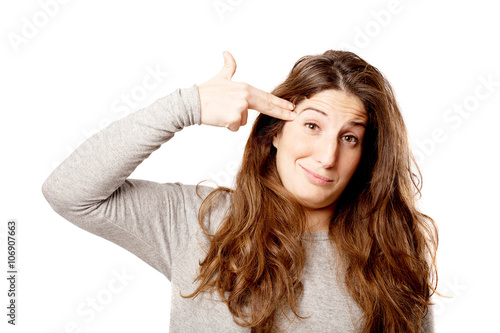 Young curvy woman gun gesture over white