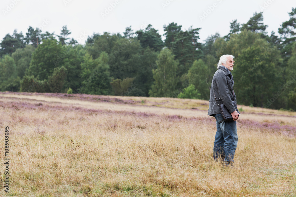 Senior man standing in meadow Senior man standing in meadow