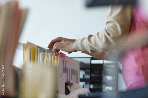 Senior woman looking through filing cabinet photo