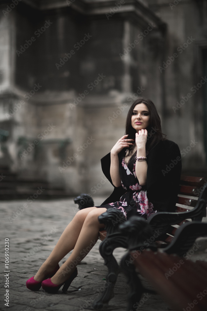 Beautiful brunette young woman posing on the street in old city Beautiful brunette young woman posing on the street in old city