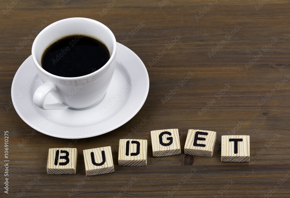 Coffee cup on a wooden table and text - BUDGET Coffee cup on a wooden table and text - BUDGET