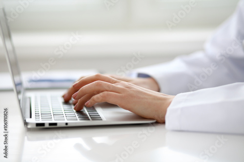 Female doctor typing on laptop  close up