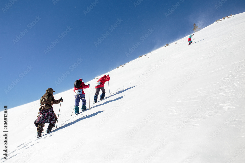 mountaineering group of tourists climbing up the snow covered mo