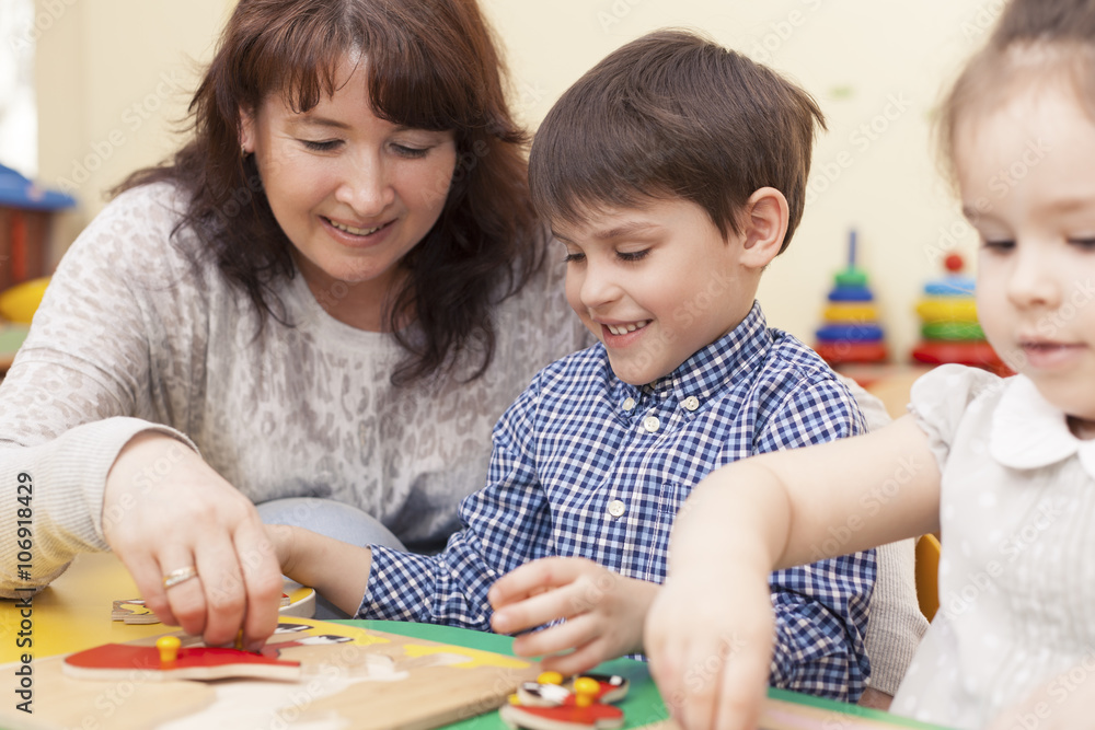 beautiful caucasian teacher collects the puzzle with a pupil beautiful caucasian teacher collects the puzzle with a pupil