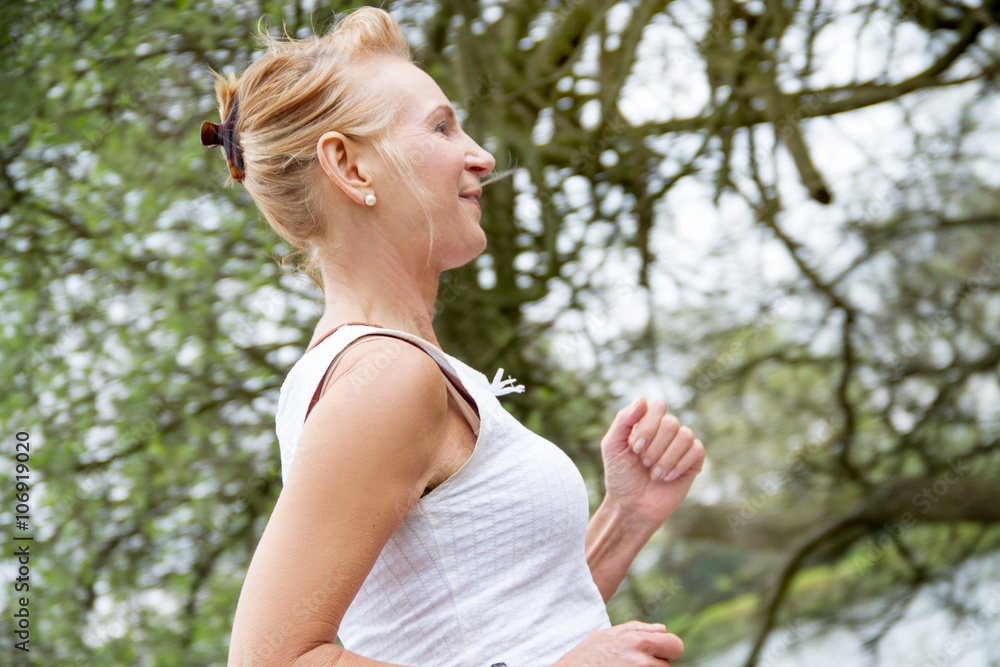 Mature woman running in park Mature woman running in park