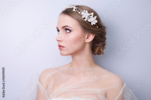 beautiful woman  bride with tiara on head  on bright background , copy space.
 photo