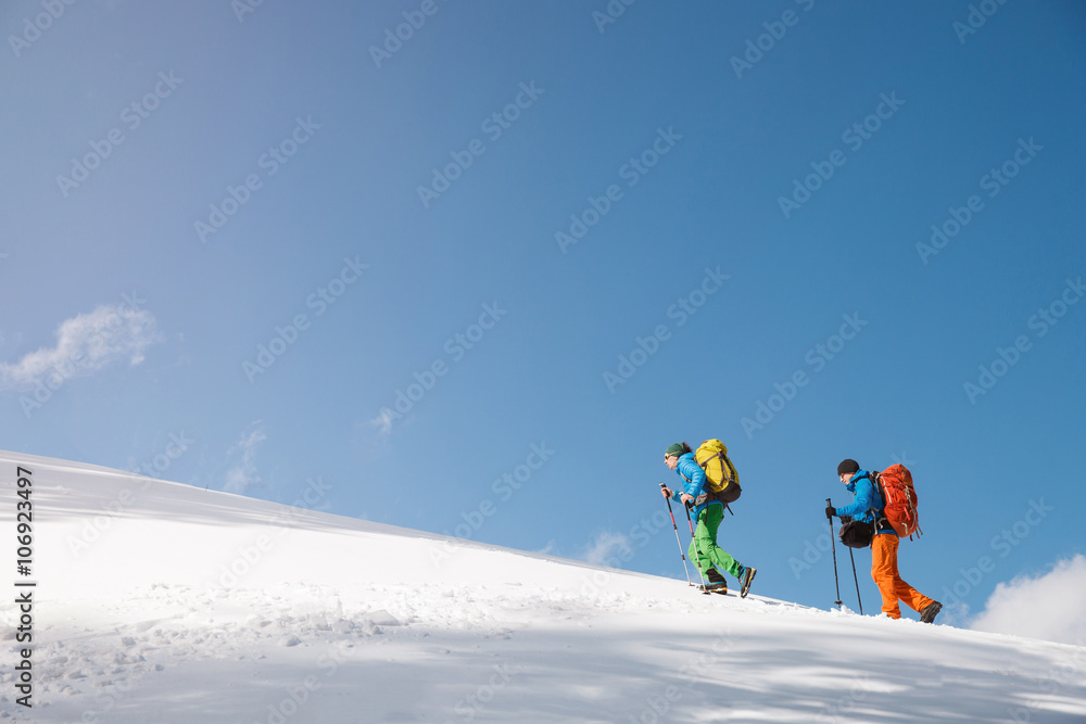 Two hikers against blue sky in winter mountains. Two hikers against blue sky in winter mountains.