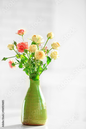 Beautiful spring flowers in vase on window background