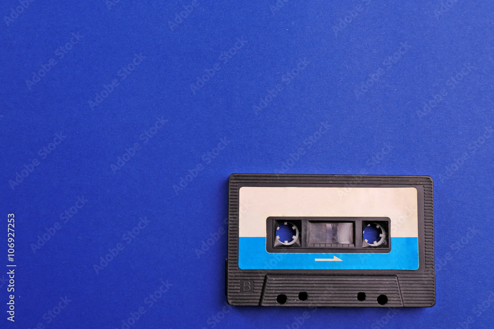 Old audio cassette on blue background Old audio cassette on blue background