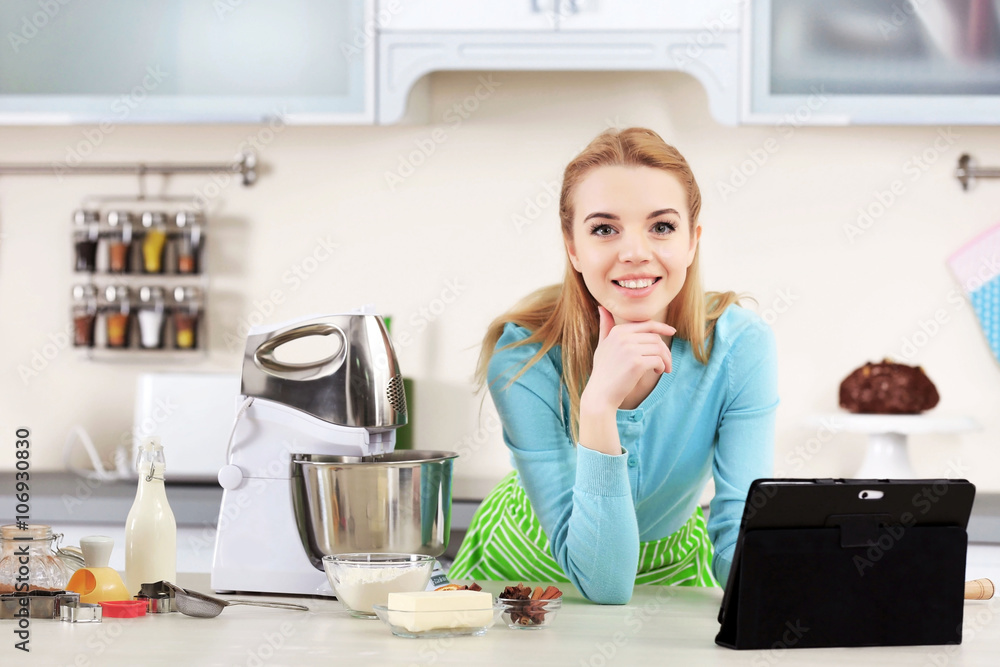 Young woman using a tablet computer to follow a recipe