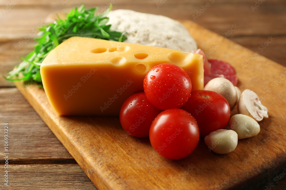 Fresh dough and other different ingredients for pizza on wooden background Fresh dough and other different ingredients for pizza on wooden background