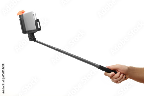 Hand holding stick for making photo with mobile phone, isolated on white