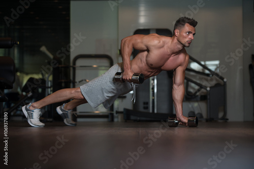 Bodybuilder Doing Push Ups With Dumbbells On Floor