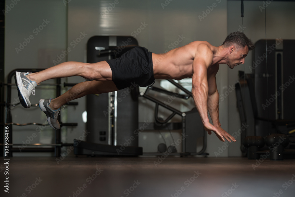 Young Man Doing Extreme Push Ups On Floor