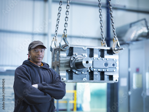 Engineer with industrial gearbox in engineering factory, portrait