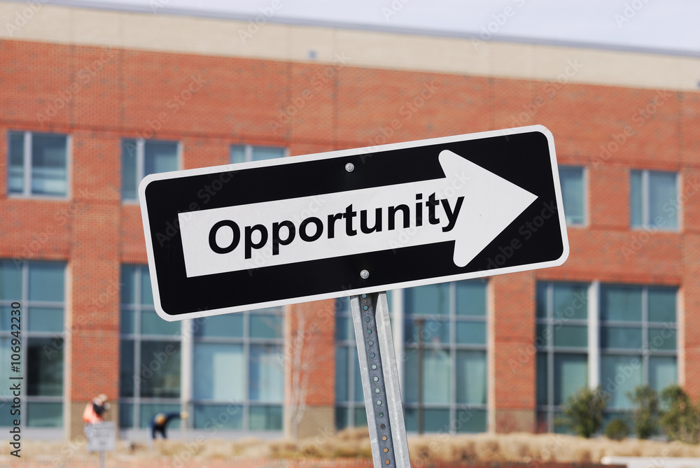 arrow sign with text opportunity in front of industrial building arrow sign with text opportunity in front of industrial building