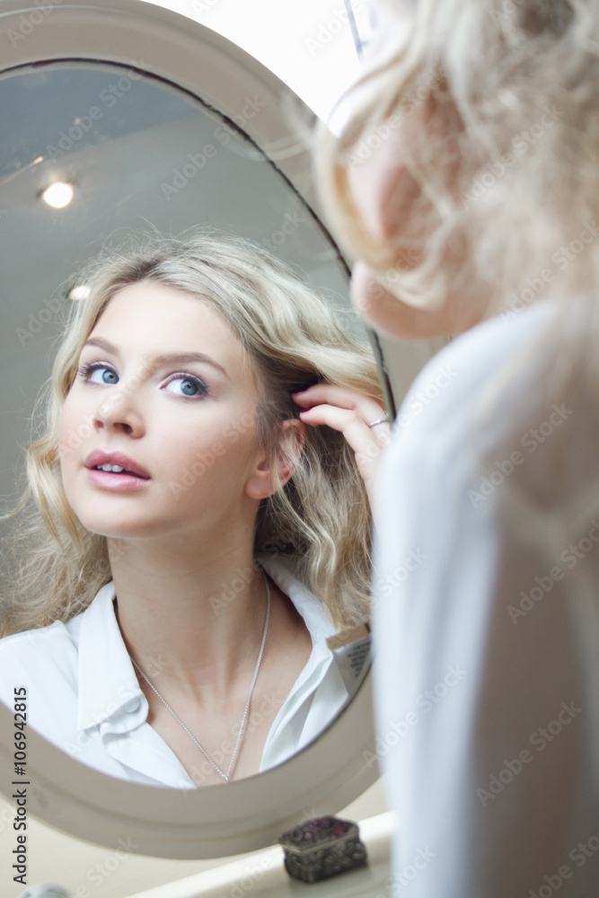Teenage girl looking in mirror, doing her hair Stock Photo | Adobe Stock