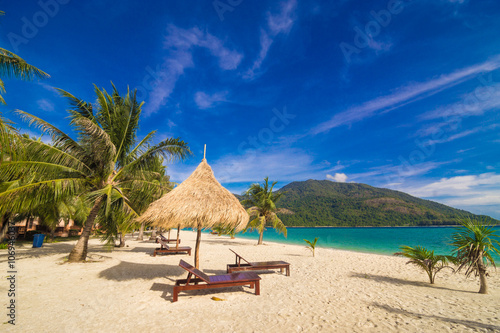 Vacation time background of two beach lounge chairs under grass