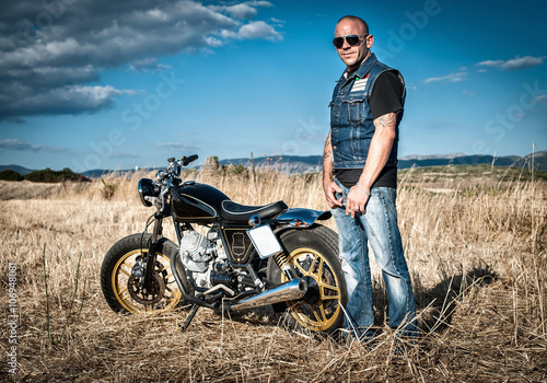Portrait of male motorcyclist in plain landscape, Cagliari, Sardinia, Italy